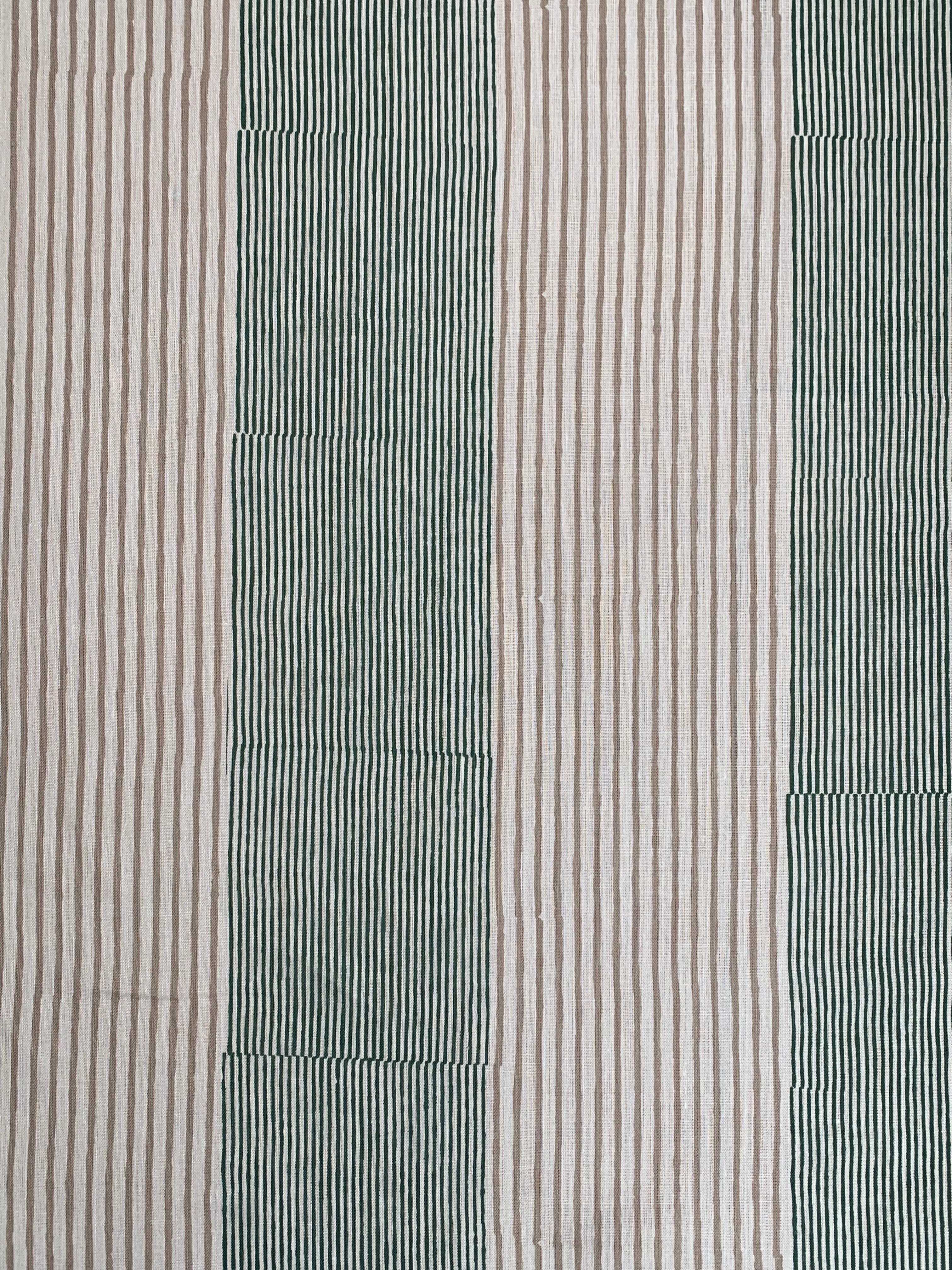 Detail of fabric in an irregular stripe print in green and brown on a white field.