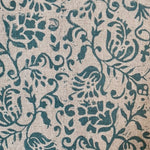 Close-up of fabric in a botanical print in blue on a light brown field.