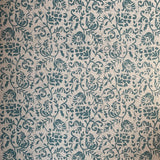 Detail of fabric in a botanical print in blue on a light brown field.