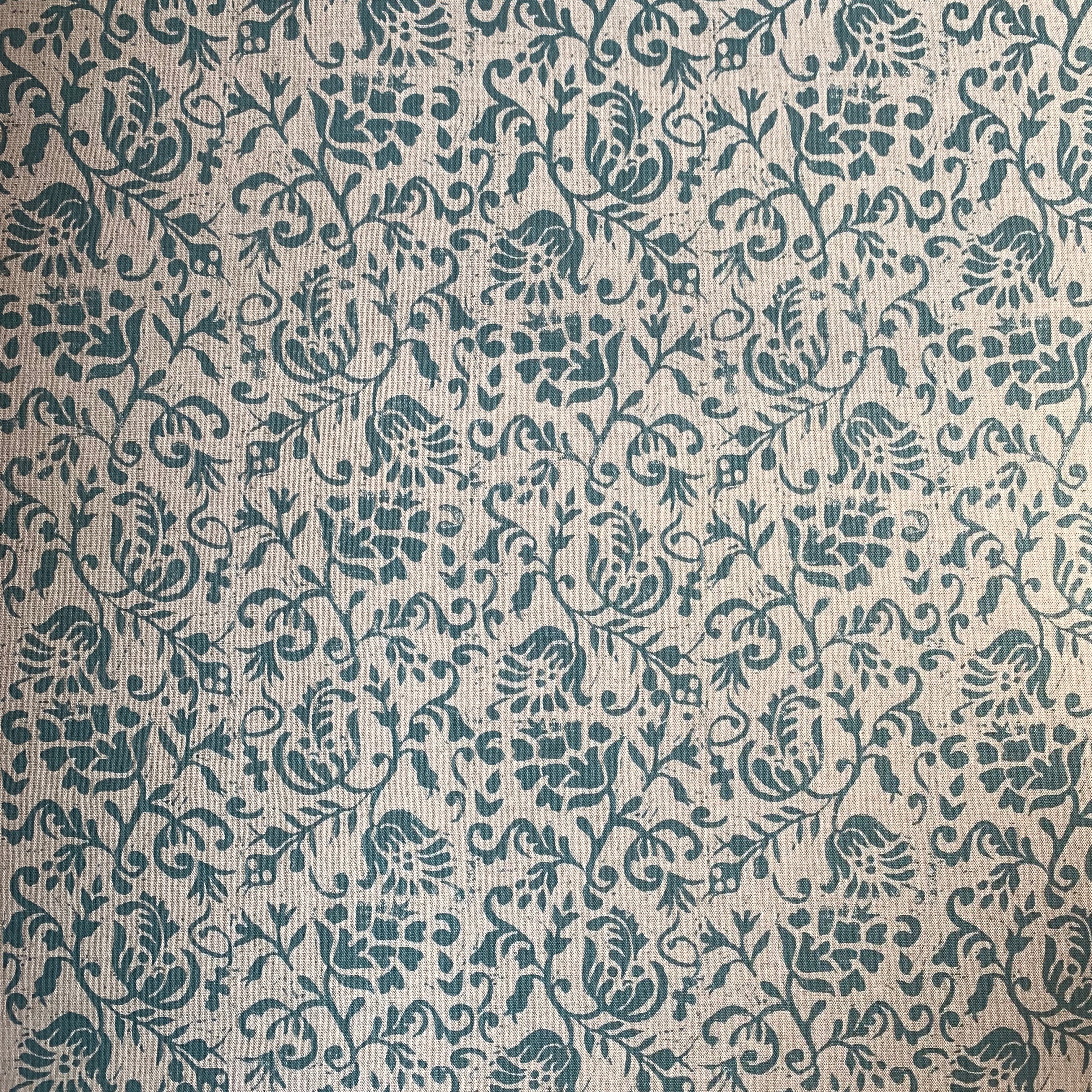 Detail of fabric in a botanical print in blue on a light brown field.