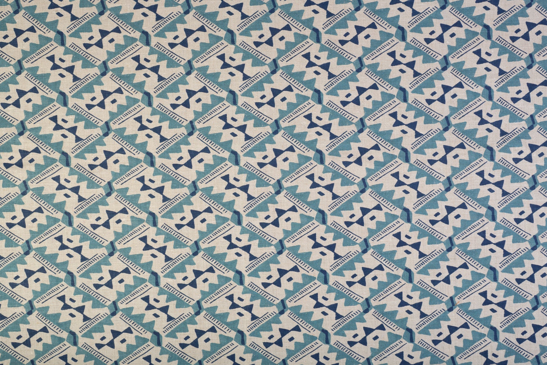 Detail of fabric in painterly diamond print in blue and navy on a white field.