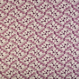 Detail of fabric in painterly diamond print in shades of purple on a white field.