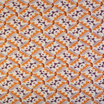 Detail of fabric in painterly diamond print in maroon and orange on a white field.