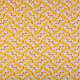 Detail of fabric in painterly diamond print in yellow and orange on a white field.