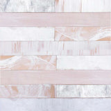 Detail of leather wall tiles in a variety of textures and finishes in light pink and cream.