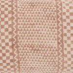 Detail of an mixed motif checkerboard pattern in dusty brown on natural linen