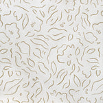 Detail of fabric in a minimalist floral print in brown on a cream field.