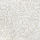 Detail of fabric in a minimalist floral print in brown on a cream field.
