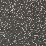 Detail of fabric in a minimalist floral print in cream on a charcoal field.