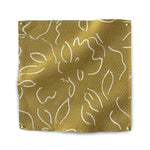 Square fabric swatch in a minimalist floral print in cream on a brown field.