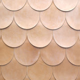 Detail of leather wall tiles in an overlaid scallop pattern in light brown.