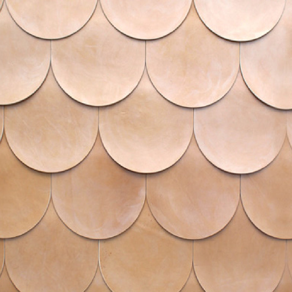 Detail of leather wall tiles in an overlaid scallop pattern in light brown.