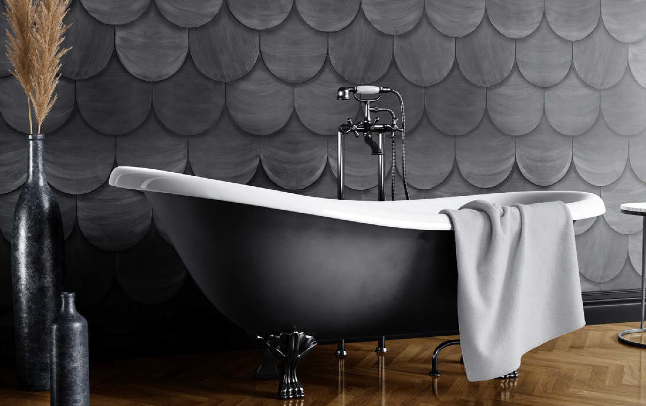 A clawfoot tub stands in front of a wall covered in leather tiles in a scallop pattern in gray.