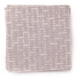 A stack of fabric swatches in a small-scale grid pattern in shades of heather.