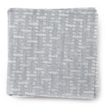 A stack of fabric swatches in a small-scale grid pattern in shades of light blue.