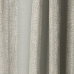 Draped printed fabric in a scrolling floral stripe pattern in cream on a light blue-gray field.