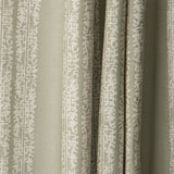 Draped printed fabric in a scrolling floral stripe pattern in cream on a light sage field.