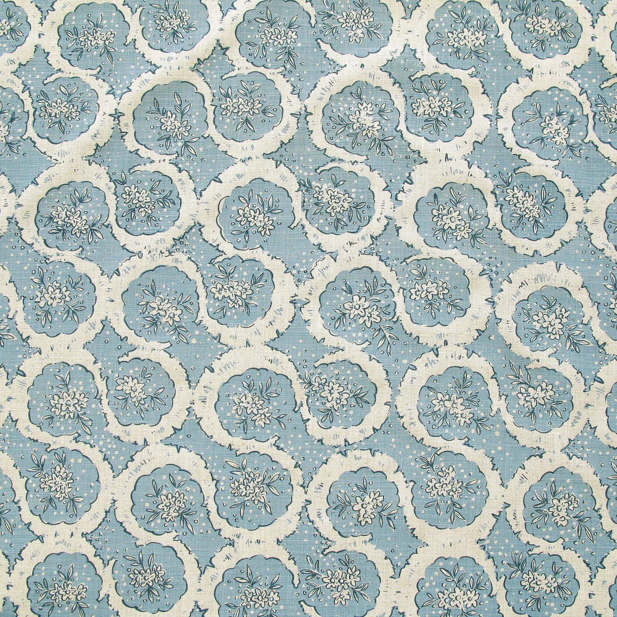 Detail of fabric in a meandering floral grid print in cream and navy on a light blue field.
