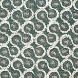 Detail of fabric in a meandering floral grid print in white and brown on a dark green field.