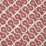 Detail of fabric in a meandering floral grid print in white and maroon on a red field.