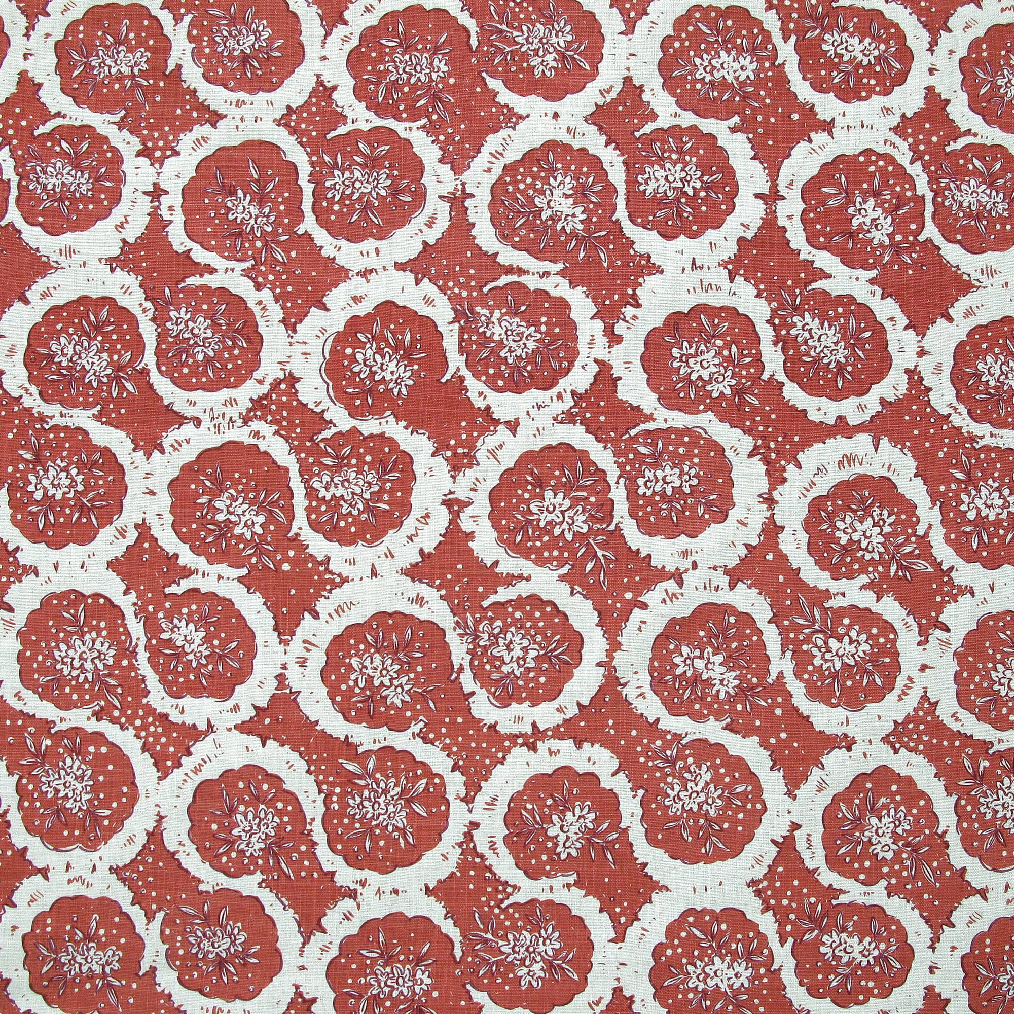 Detail of fabric in a meandering floral grid print in white and maroon on a red field.