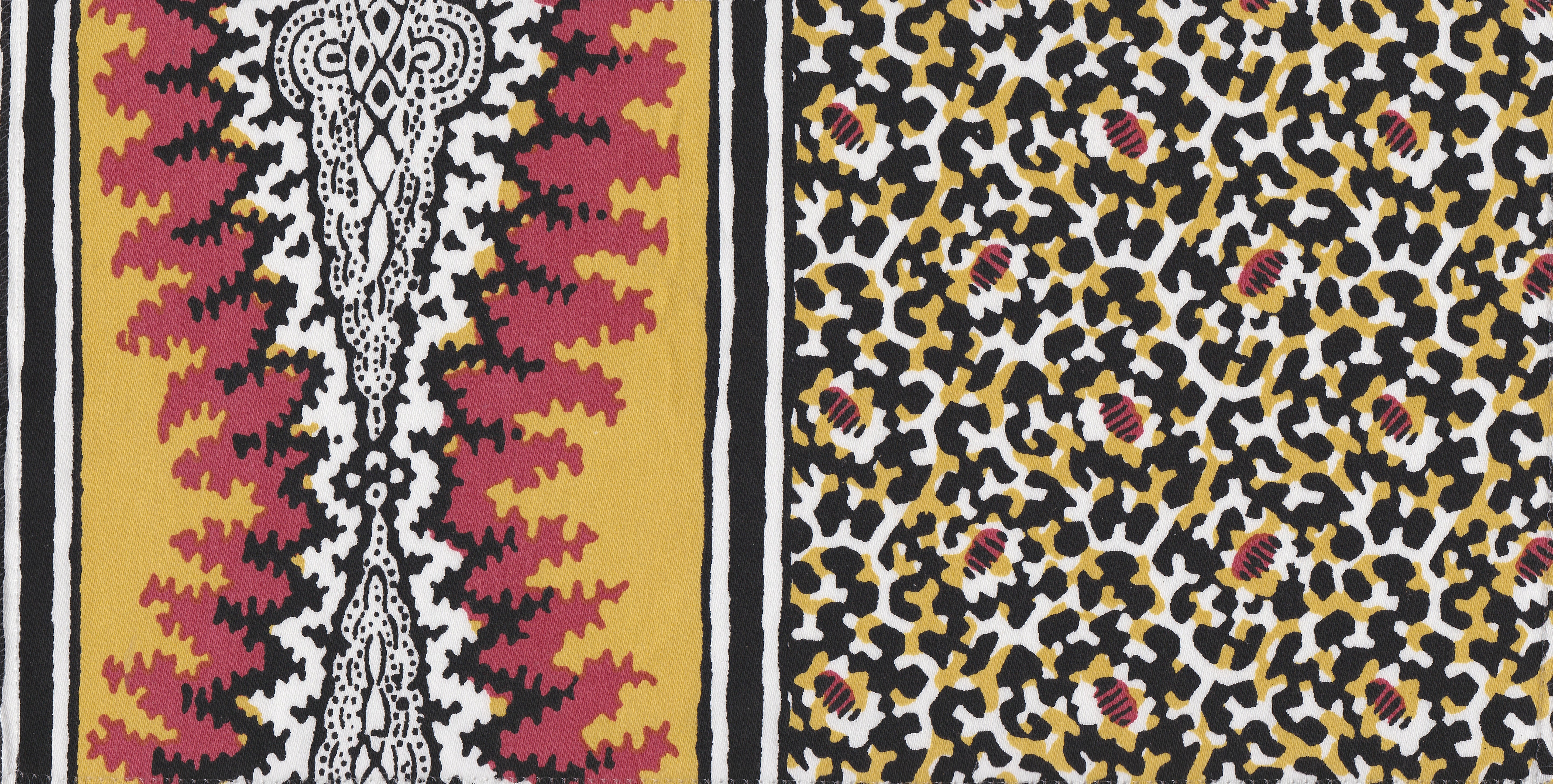 Detail of fabric in a bordered paisley print in shades of black, red, yellow and white.