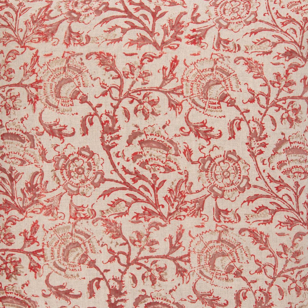 Detail of fabric in a dense botanical print in red and brown on a tan field.