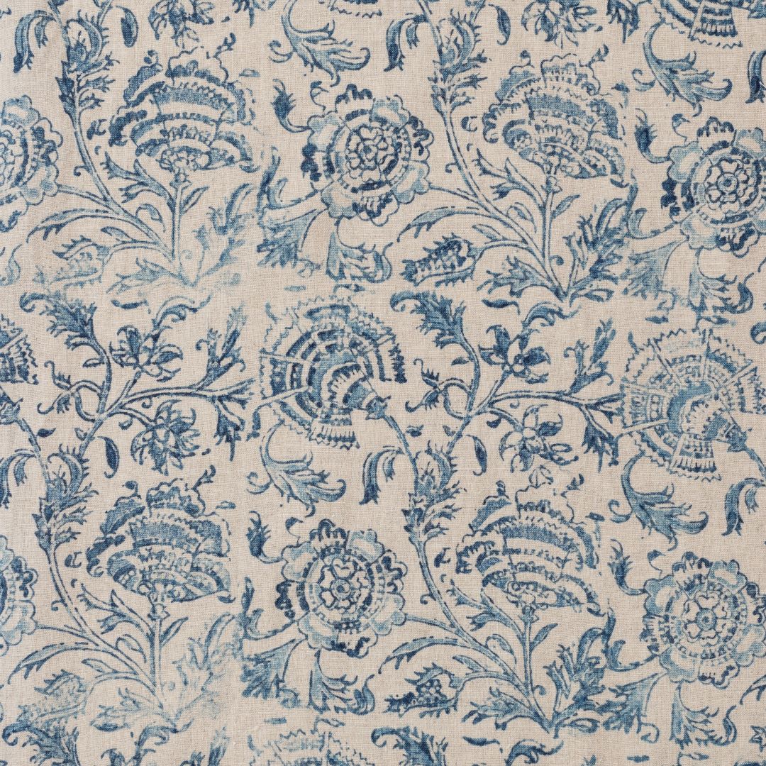 Detail of fabric in a dense botanical print in blue and navy on a tan field.