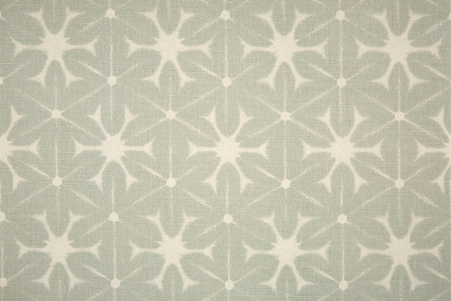 Detail of fabric in a shibori grid print in white on a gray field.