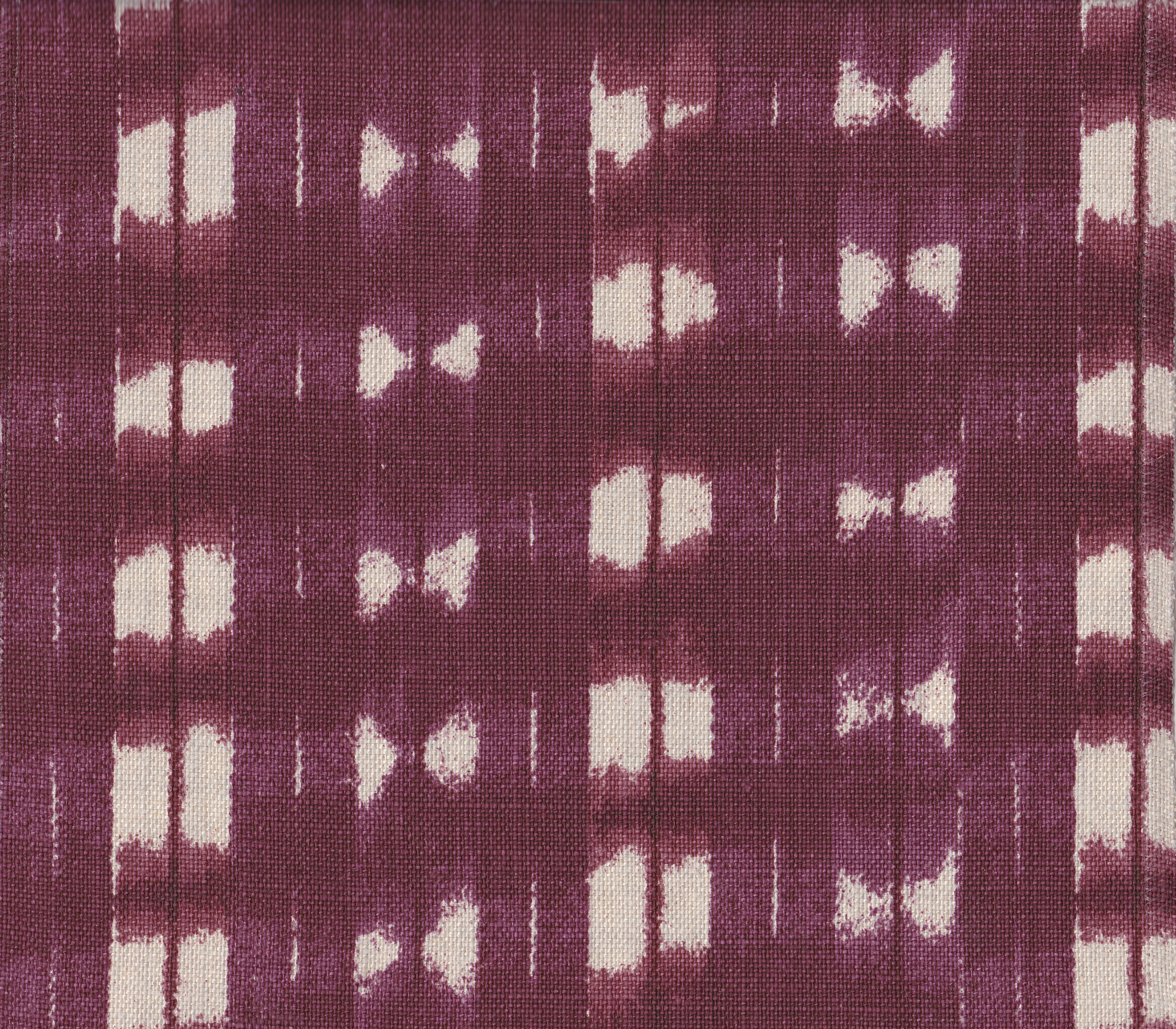 Detail of fabric in a textural shibori print in shades of purple on a greige field.