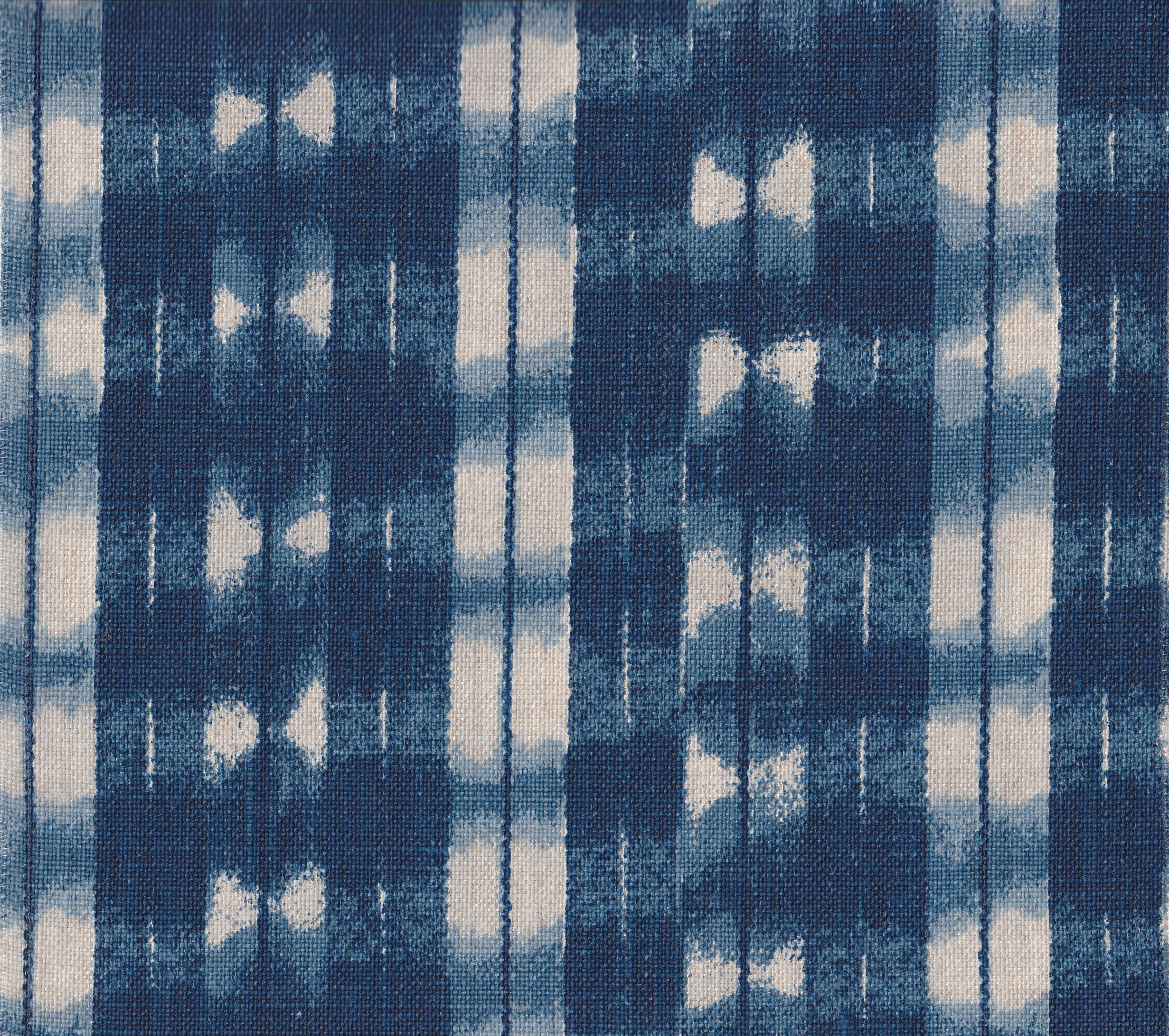 Detail of fabric in a textural shibori print in shades of navy on a greige field.