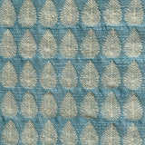 Detail of fabric woven in a repeating leaf print in shades of blue and gold.