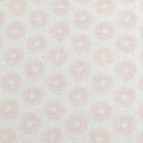 Detail of fabric in a repeating circular geometric print in light pink on a greige field.