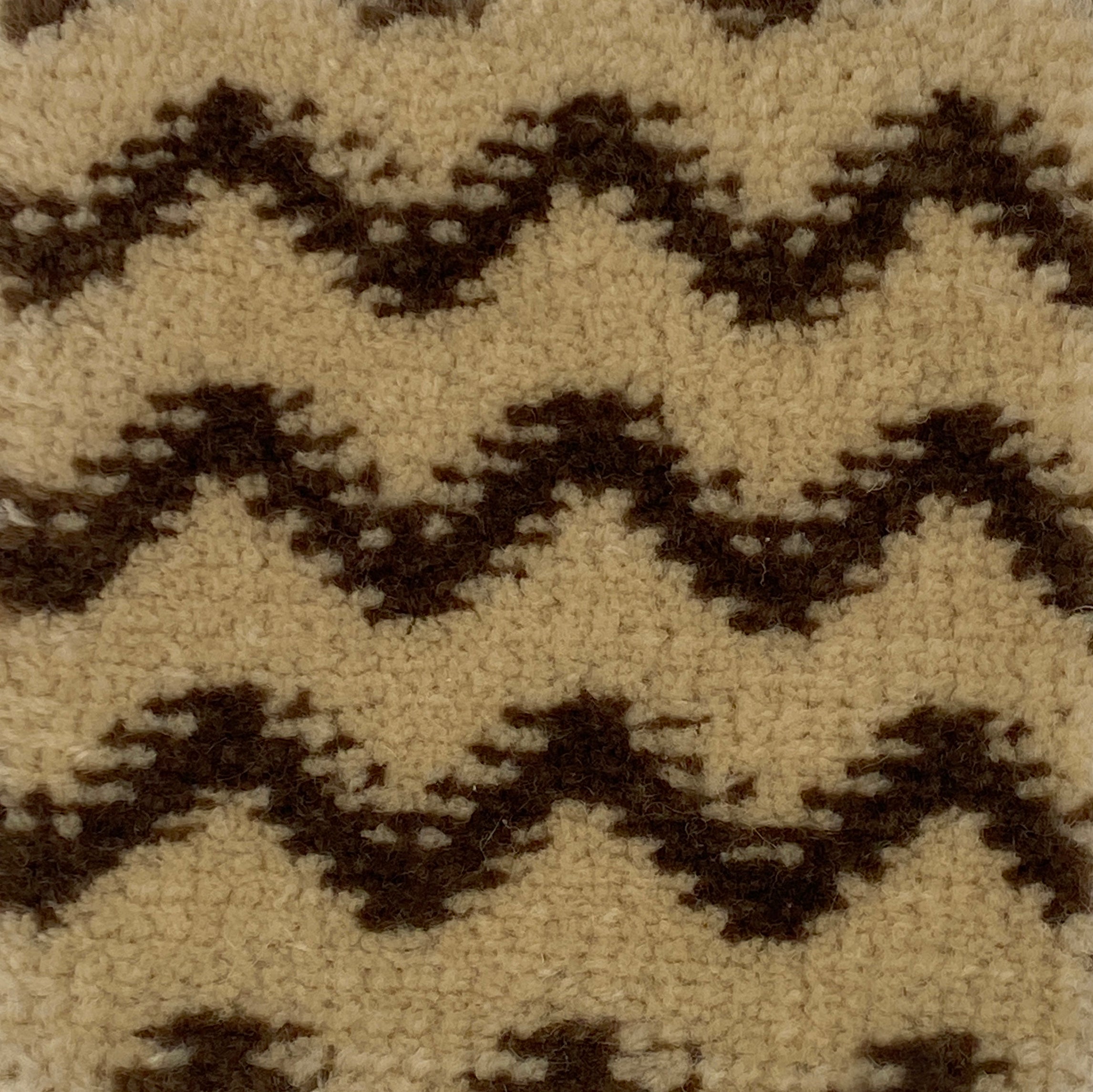 Close-up of a patterned carpet with black and beige zig zag design