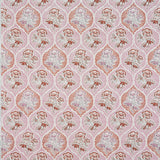 Detail of fabric in a floral damask print in shades of pink and red on a cream field.