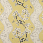 Detail of fabric in a striped bird and tree print in gray and white on a yellow field.