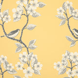 Detail of wallpaper in a bird and tree print in gray and white on a yellow field.