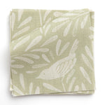 A stack of fabric swatches in a playful bird and leaf print in cream on a light green field.