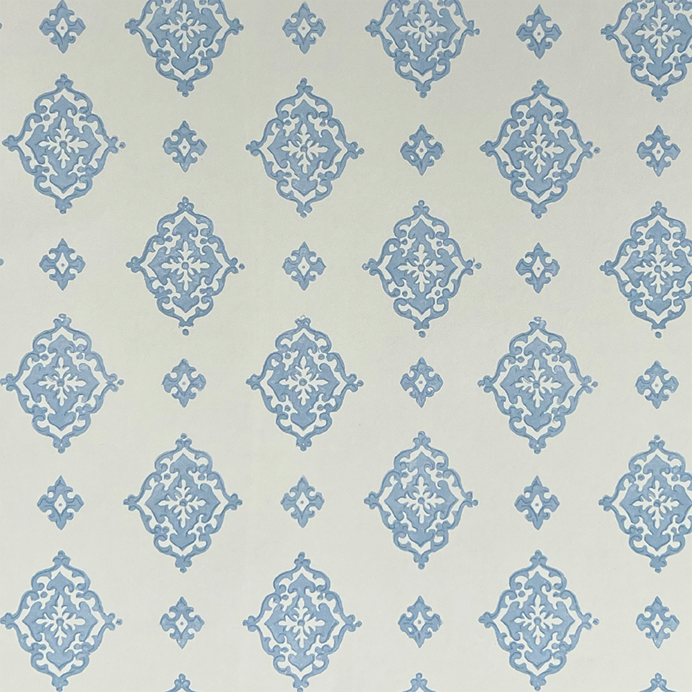 Detail of fabric in a floral damask print in blue on a cream field.