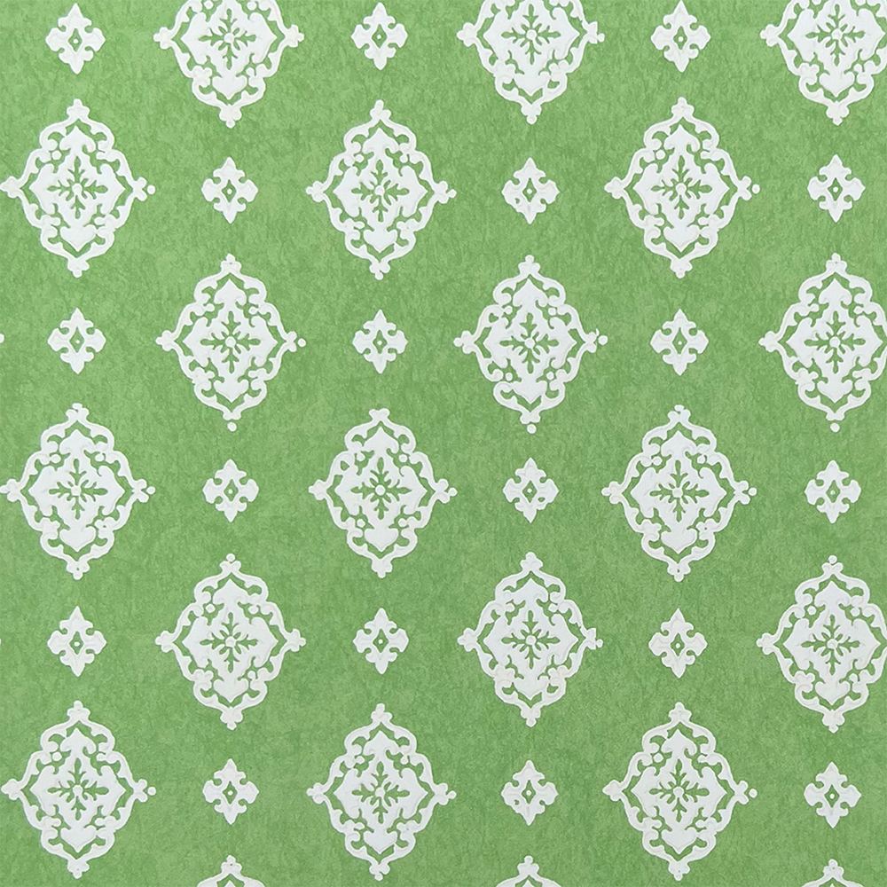 Detail of fabric in a floral damask print in white on a green field.