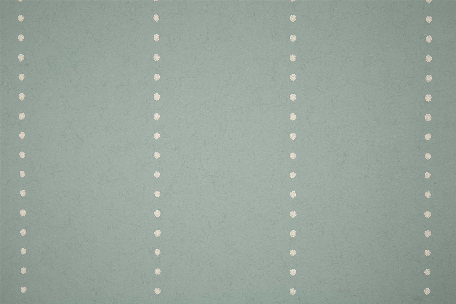 Detail of wallpaper in a minimalist dotted stripe pattern in cream on a blue-gray field.