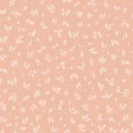 Detail of fabric in a minimal repeating leaf print in cream on a light pink field.