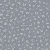 Detail of fabric in a minimal repeating leaf print in cream on a blue-gray field.