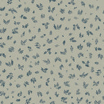 Detail of fabric in a minimal repeating leaf print in navy on a light green field.