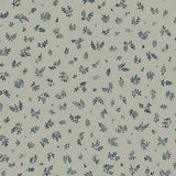 Detail of fabric in a minimal repeating leaf print in navy on a light green field.