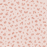 Detail of fabric in a minimal repeating leaf print in red on a light pink field.