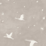 Detail of fabric in a repeating print of birds and stars in white on a gray watercolor field.