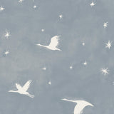 Detail of fabric in a repeating print of birds and stars in white on a blue-gray watercolor field.