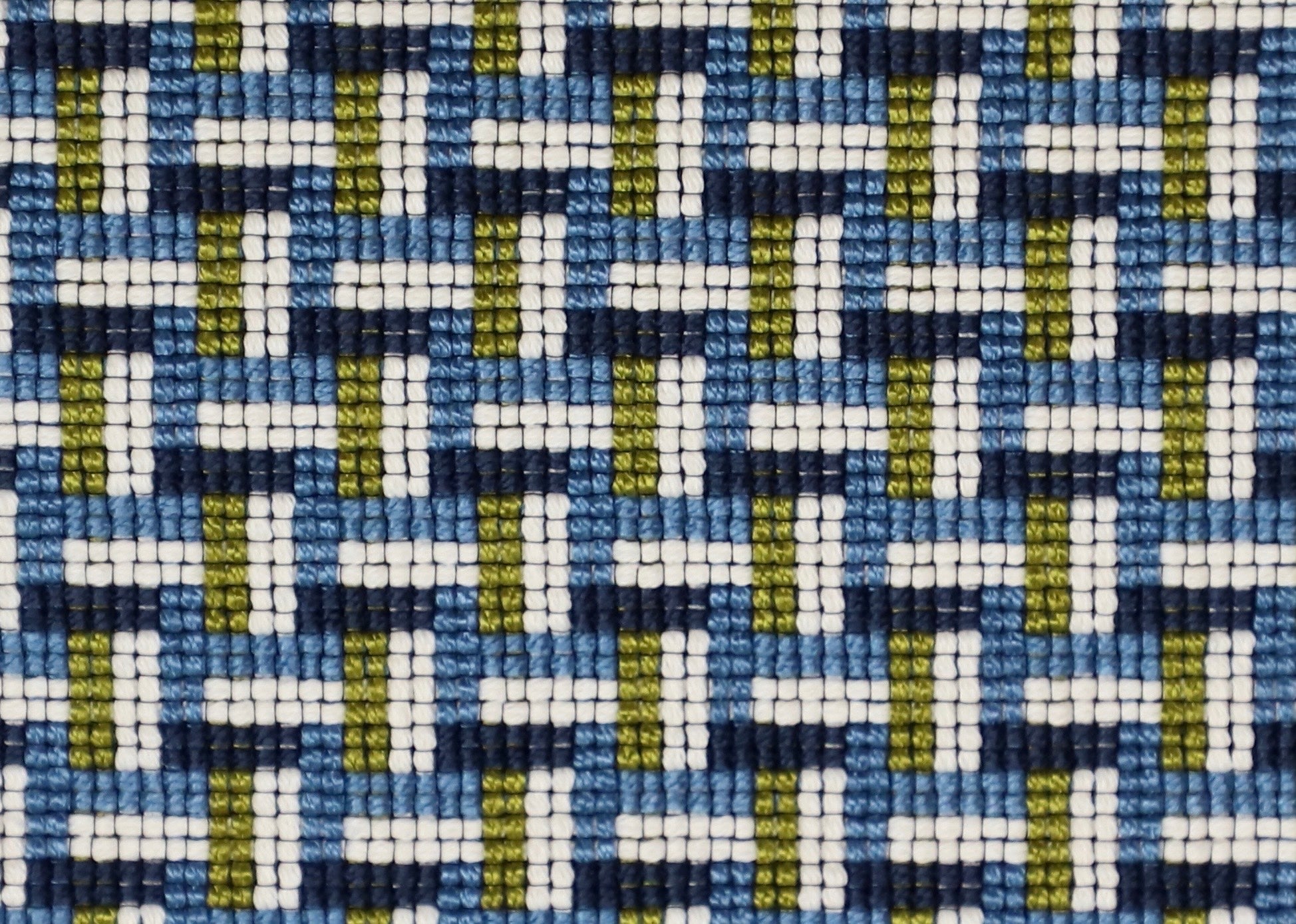 Detail of a woven stair step pattern in navy blue, chambray, white and lime green. 