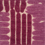 Close-up of a flatweave rug with a raised pink linear design.